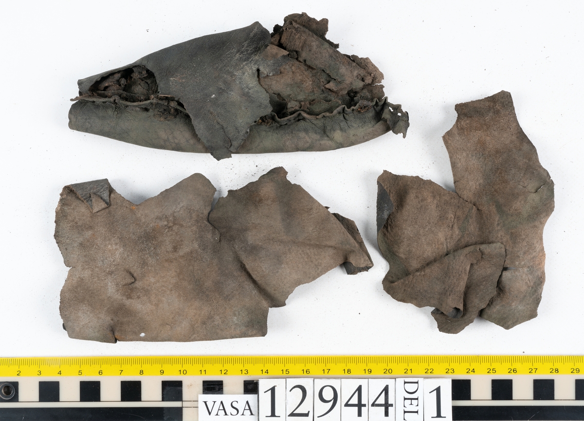 Ett 110-tal delar och fragment till sko: sulor, delar från klack, inlägg, ovanläder, slejf, ett näverfragment mm. Merparten av lädret är spaltat och fragmentariskt.