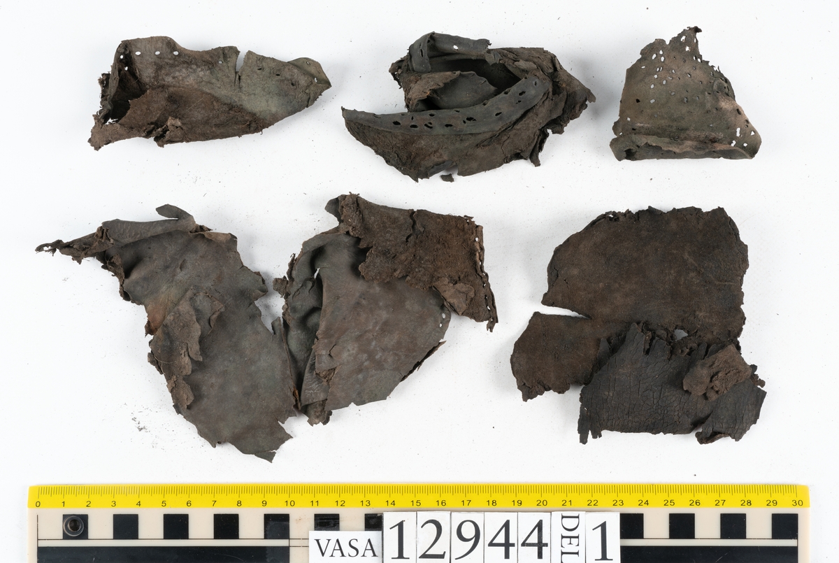 Ett 110-tal delar och fragment till sko: sulor, delar från klack, inlägg, ovanläder, slejf, ett näverfragment mm. Merparten av lädret är spaltat och fragmentariskt.