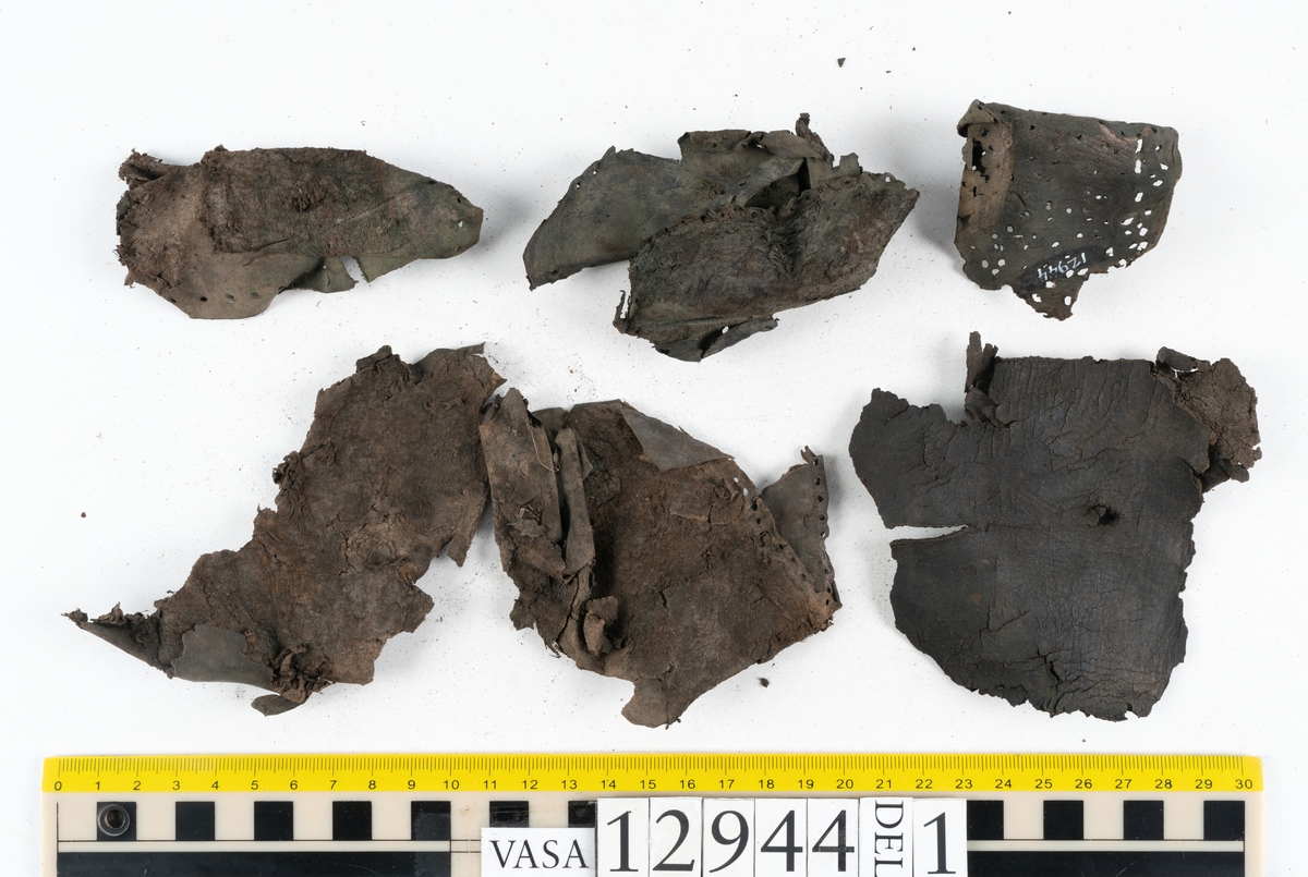 Ett 110-tal delar och fragment till sko: sulor, delar från klack, inlägg, ovanläder, slejf, ett näverfragment mm. Merparten av lädret är spaltat och fragmentariskt.