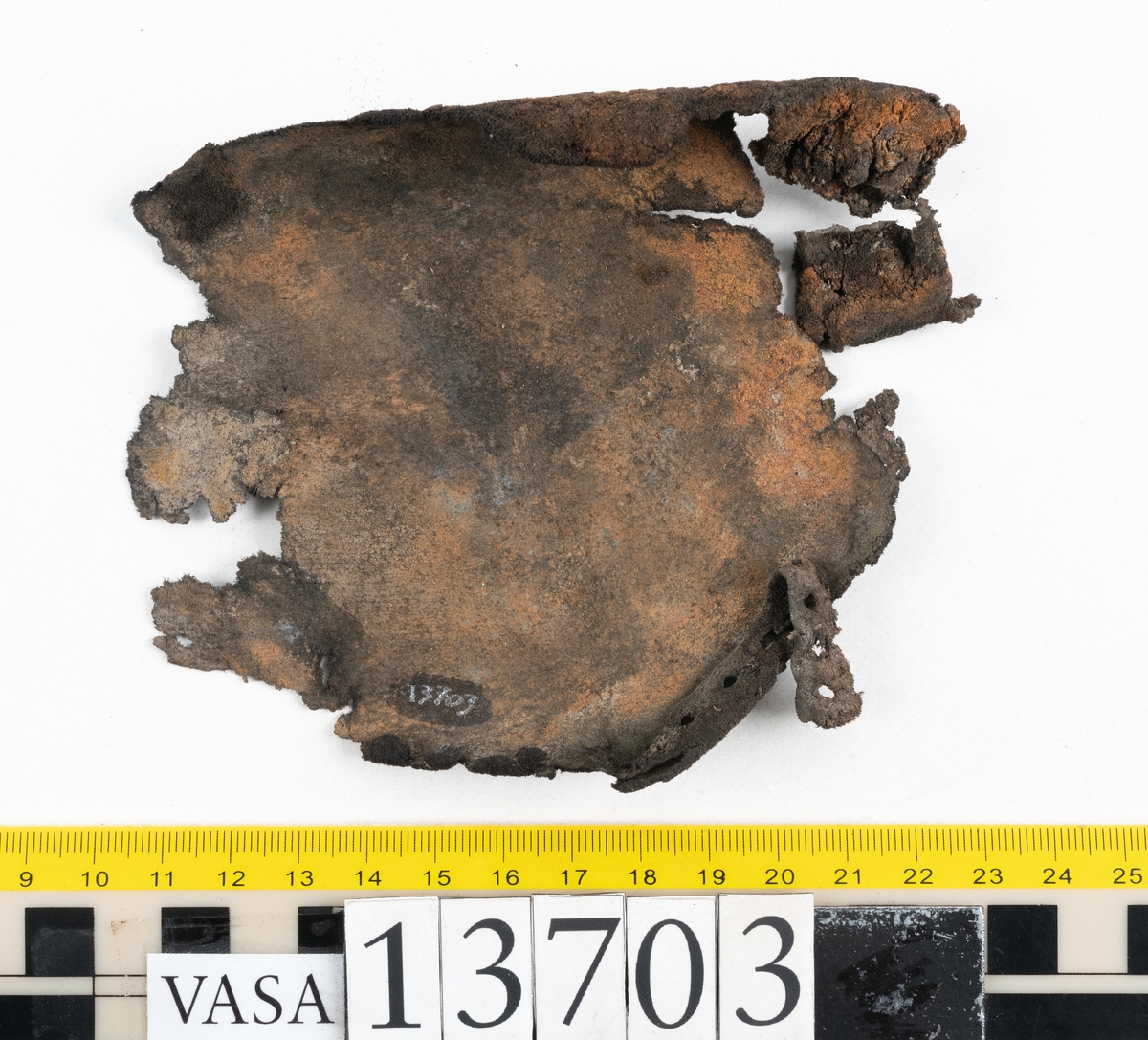 Delar och fragment av sko: ovanläder, skobotten, sula, skopligg samt fragment.

Ovanlädret är fragmentariskt och spaltad samt har rostfärgade utfällningar.

Skobottnen har kvarsittande skopligg och tråd. Klacken är uppbyggd av tre eller fyra klacklappar. Lädret har en grå beläggning, troligtvis av lera, samt rostfärgade utfällningar.

En sula med kvarsittande tråd. Lädret till sulan är kraftig.

Totalt fyra löst liggande skopligg och nio fragment/delar.