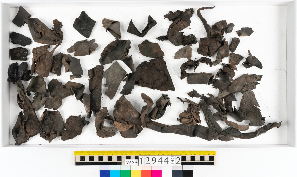 Ett 110-tal delar och fragment till sko: sulor, delar från klack, inlägg, ovanläder, slejf, ett näverfragment mm. Merparten av lädret är spaltat och fragmentariskt.