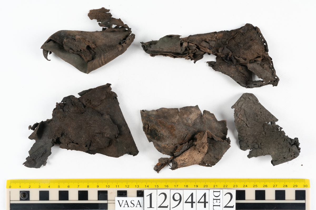 Ett 110-tal delar och fragment till sko: sulor, delar från klack, inlägg, ovanläder, slejf, ett näverfragment mm. Merparten av lädret är spaltat och fragmentariskt.