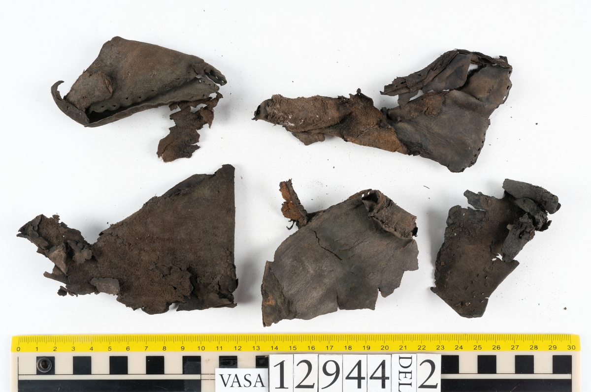 Ett 110-tal delar och fragment till sko: sulor, delar från klack, inlägg, ovanläder, slejf, ett näverfragment mm. Merparten av lädret är spaltat och fragmentariskt.
