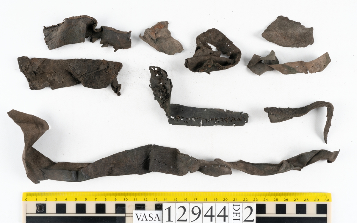 Ett 110-tal delar och fragment till sko: sulor, delar från klack, inlägg, ovanläder, slejf, ett näverfragment mm. Merparten av lädret är spaltat och fragmentariskt.