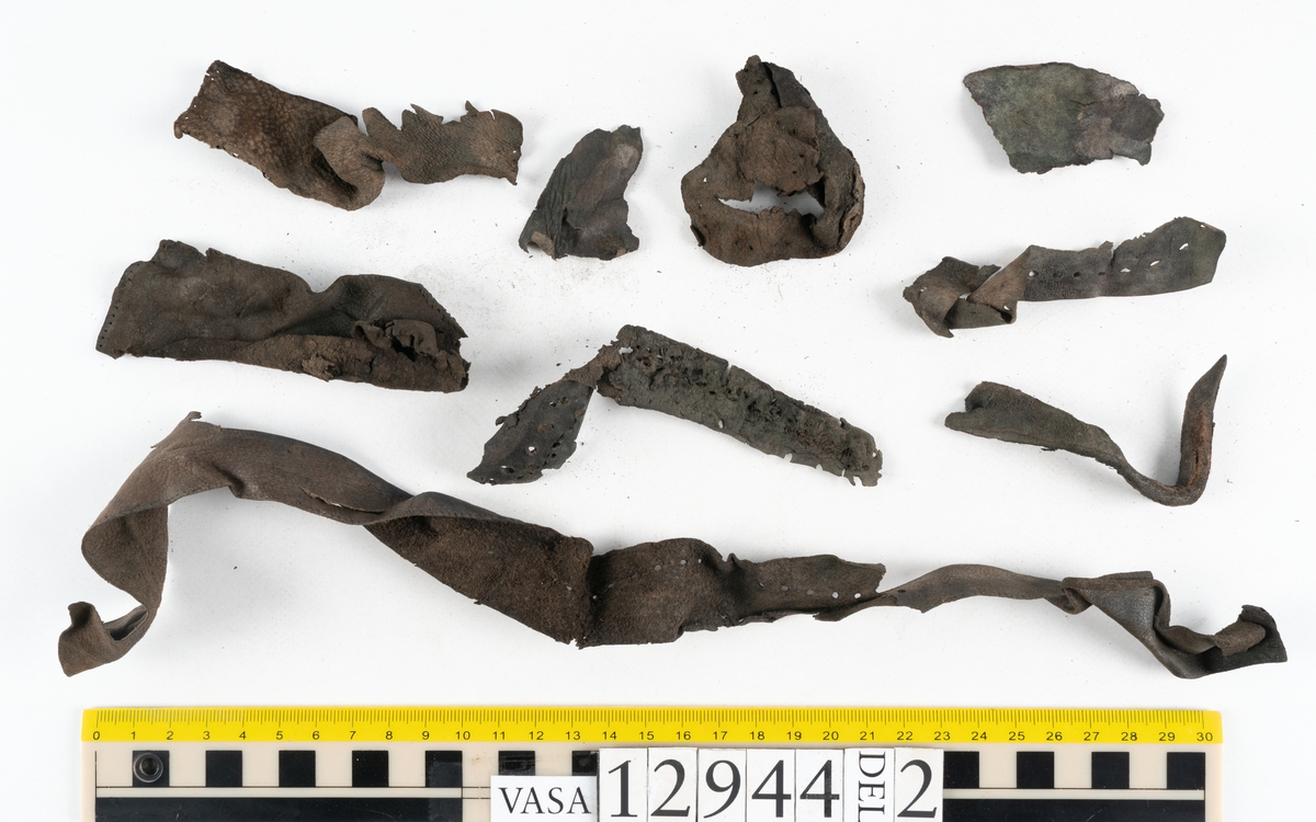 Ett 110-tal delar och fragment till sko: sulor, delar från klack, inlägg, ovanläder, slejf, ett näverfragment mm. Merparten av lädret är spaltat och fragmentariskt.