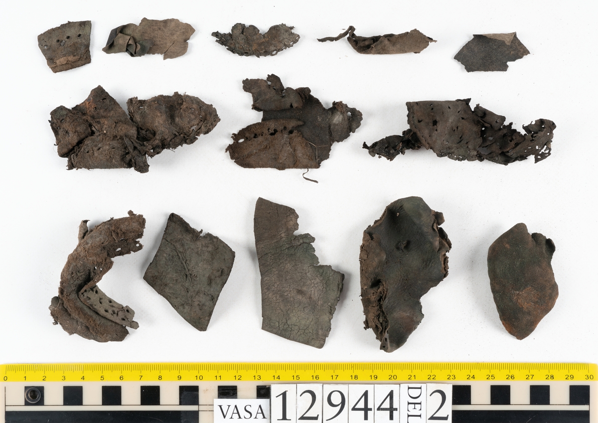 Ett 110-tal delar och fragment till sko: sulor, delar från klack, inlägg, ovanläder, slejf, ett näverfragment mm. Merparten av lädret är spaltat och fragmentariskt.