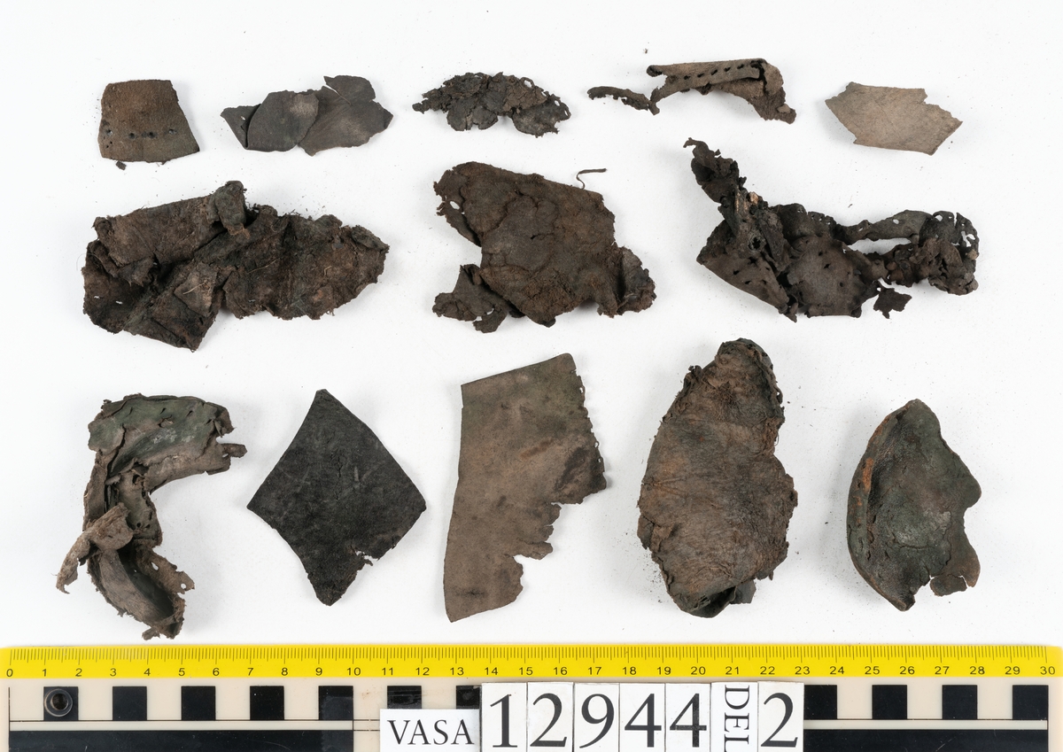 Ett 110-tal delar och fragment till sko: sulor, delar från klack, inlägg, ovanläder, slejf, ett näverfragment mm. Merparten av lädret är spaltat och fragmentariskt.