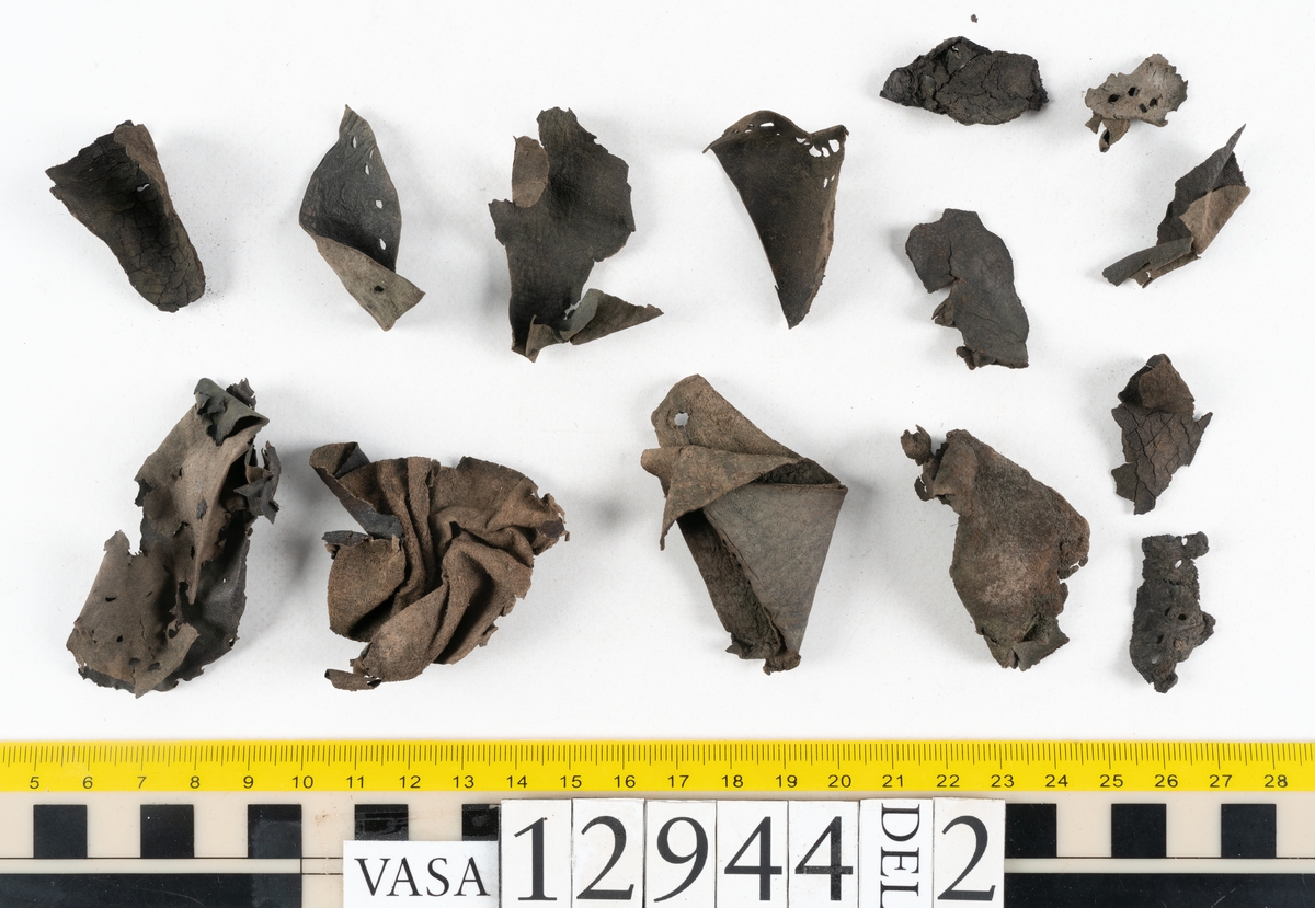 Ett 110-tal delar och fragment till sko: sulor, delar från klack, inlägg, ovanläder, slejf, ett näverfragment mm. Merparten av lädret är spaltat och fragmentariskt.