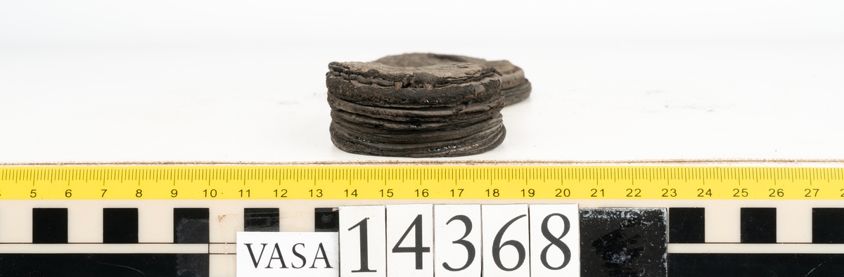 Dokumentation 1996:
Delar av sko: skobotten samt ett trettiotal fragment av ovanläder, holtrand m m.
Skobottnen består av tre sulor, holtrand och sex klacklappar. Mellan två av sulorna sitter klacklapparna fästade. En del av bakkappan sitter fästad vid bottnen.  Bottnen har kvarsittande tråd och vid hälpartiet finns kvarsittande skopligg.

Dokumentation 2022:
Skobotten till en randsko. Tillverkad i läder, med en läderklack. Skapades på en rak läst och bars på vänster fot. Inga dekorationer. Mittensulorna är delaminerade och är skurna längst med deras mittenpunkt. Randen är intakt och tå-delen är unik. 
För mer information, se Uppritning under Länkade filer.

Text in english:
This is the bottom unit of a shoe, made of leather, randed construction with a spring heel, made on a straight last and worn on the left foot, with no decorative features. The two midsoles are heavily delaminated and there is a slice along the centre of the sole. The rand is intact, and the toe wear is unique.
For more information, go to Länkade filer: Uppritning