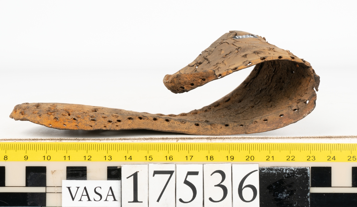 Sula med kantigt format tåparti. Sulan är täckt av kvarsittande skopligg samt hål efter skopligg. På sulans köttsida löper stygnshål. Sulan ligger vikt.
Lädret är kraftigt.