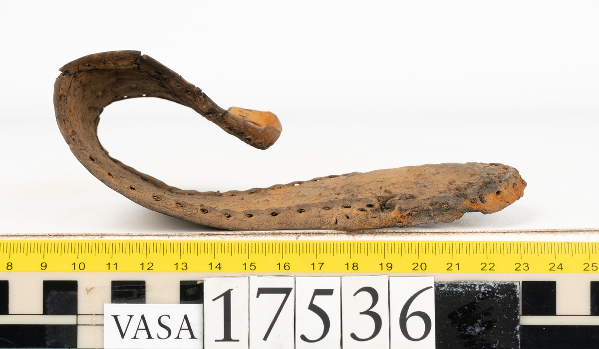 Sula med kantigt format tåparti. Sulan är täckt av kvarsittande skopligg samt hål efter skopligg. På sulans köttsida löper stygnshål. Sulan ligger vikt.
Lädret är kraftigt.