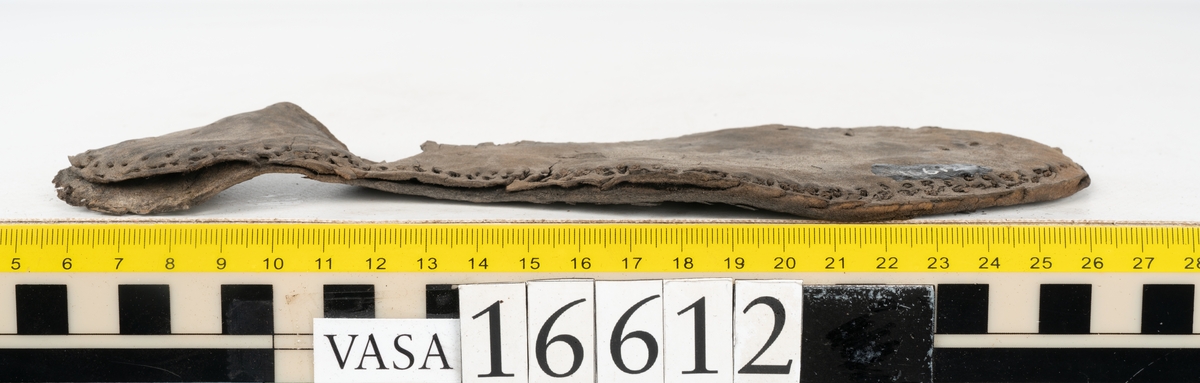 Delar och fragment av två skobottnar till höger- och vänstersko. Totalt 18 delar och fragment.
Sju sulor med kvarsittande tråd. Sulornas längd varierar mellan 220-230 mm, största bredden varierar mellan 65-75 mm, minsta bredden mellan 25-35 mm och hälbredden mellan 45-50 mm. Lädret till sulorna är kraftigt.
Klackar 16612 samt 16612:1 består av vardera fem klacklappar med kvarsittandskopligg. Klacklapparna är spaltade. I materialet finns en löst liggande klacklapp som tillhör klack 16621:1.
Tre delar holtrand med kvarsittande tråd.
Tre fragment från skobotten.