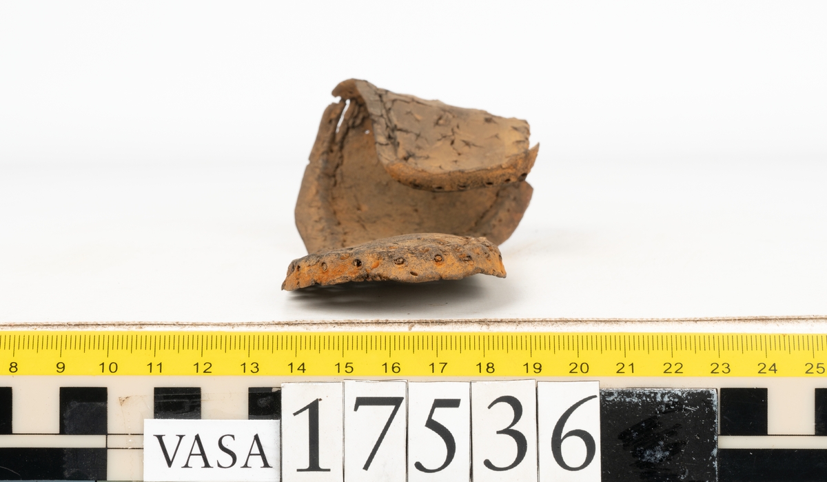 Sula med kantigt format tåparti. Sulan är täckt av kvarsittande skopligg samt hål efter skopligg. På sulans köttsida löper stygnshål. Sulan ligger vikt.
Lädret är kraftigt.