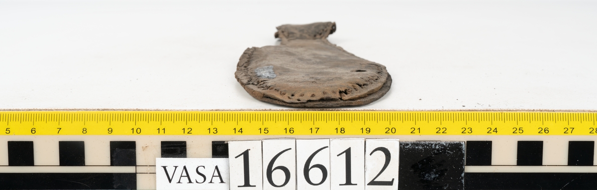 Delar och fragment av två skobottnar till höger- och vänstersko. Totalt 18 delar och fragment.
Sju sulor med kvarsittande tråd. Sulornas längd varierar mellan 220-230 mm, största bredden varierar mellan 65-75 mm, minsta bredden mellan 25-35 mm och hälbredden mellan 45-50 mm. Lädret till sulorna är kraftigt.
Klackar 16612 samt 16612:1 består av vardera fem klacklappar med kvarsittandskopligg. Klacklapparna är spaltade. I materialet finns en löst liggande klacklapp som tillhör klack 16621:1.
Tre delar holtrand med kvarsittande tråd.
Tre fragment från skobotten.