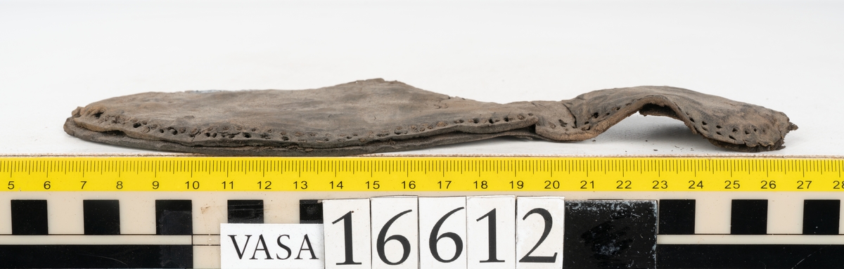 Delar och fragment av två skobottnar till höger- och vänstersko. Totalt 18 delar och fragment.
Sju sulor med kvarsittande tråd. Sulornas längd varierar mellan 220-230 mm, största bredden varierar mellan 65-75 mm, minsta bredden mellan 25-35 mm och hälbredden mellan 45-50 mm. Lädret till sulorna är kraftigt.
Klackar 16612 samt 16612:1 består av vardera fem klacklappar med kvarsittandskopligg. Klacklapparna är spaltade. I materialet finns en löst liggande klacklapp som tillhör klack 16621:1.
Tre delar holtrand med kvarsittande tråd.
Tre fragment från skobotten.