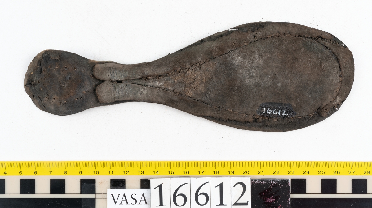 Delar och fragment av två skobottnar till höger- och vänstersko. Totalt 18 delar och fragment.
Sju sulor med kvarsittande tråd. Sulornas längd varierar mellan 220-230 mm, största bredden varierar mellan 65-75 mm, minsta bredden mellan 25-35 mm och hälbredden mellan 45-50 mm. Lädret till sulorna är kraftigt.
Klackar 16612 samt 16612:1 består av vardera fem klacklappar med kvarsittandskopligg. Klacklapparna är spaltade. I materialet finns en löst liggande klacklapp som tillhör klack 16621:1.
Tre delar holtrand med kvarsittande tråd.
Tre fragment från skobotten.