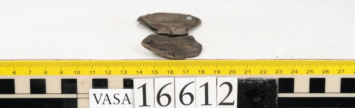 Delar och fragment av två skobottnar till höger- och vänstersko. Totalt 18 delar och fragment.
Sju sulor med kvarsittande tråd. Sulornas längd varierar mellan 220-230 mm, största bredden varierar mellan 65-75 mm, minsta bredden mellan 25-35 mm och hälbredden mellan 45-50 mm. Lädret till sulorna är kraftigt.
Klackar 16612 samt 16612:1 består av vardera fem klacklappar med kvarsittandskopligg. Klacklapparna är spaltade. I materialet finns en löst liggande klacklapp som tillhör klack 16621:1.
Tre delar holtrand med kvarsittande tråd.
Tre fragment från skobotten.