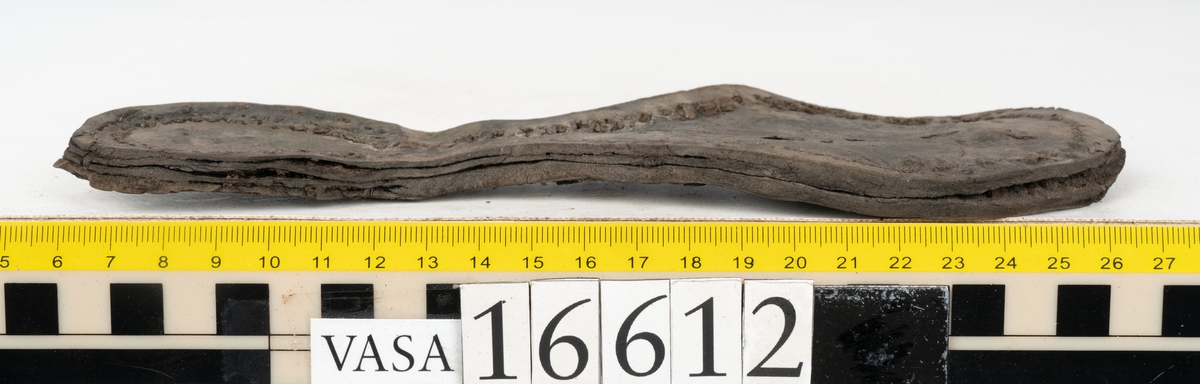 Delar och fragment av två skobottnar till höger- och vänstersko. Totalt 18 delar och fragment.
Sju sulor med kvarsittande tråd. Sulornas längd varierar mellan 220-230 mm, största bredden varierar mellan 65-75 mm, minsta bredden mellan 25-35 mm och hälbredden mellan 45-50 mm. Lädret till sulorna är kraftigt.
Klackar 16612 samt 16612:1 består av vardera fem klacklappar med kvarsittandskopligg. Klacklapparna är spaltade. I materialet finns en löst liggande klacklapp som tillhör klack 16621:1.
Tre delar holtrand med kvarsittande tråd.
Tre fragment från skobotten.
