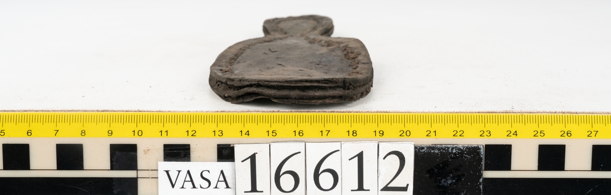 Delar och fragment av två skobottnar till höger- och vänstersko. Totalt 18 delar och fragment.
Sju sulor med kvarsittande tråd. Sulornas längd varierar mellan 220-230 mm, största bredden varierar mellan 65-75 mm, minsta bredden mellan 25-35 mm och hälbredden mellan 45-50 mm. Lädret till sulorna är kraftigt.
Klackar 16612 samt 16612:1 består av vardera fem klacklappar med kvarsittandskopligg. Klacklapparna är spaltade. I materialet finns en löst liggande klacklapp som tillhör klack 16621:1.
Tre delar holtrand med kvarsittande tråd.
Tre fragment från skobotten.