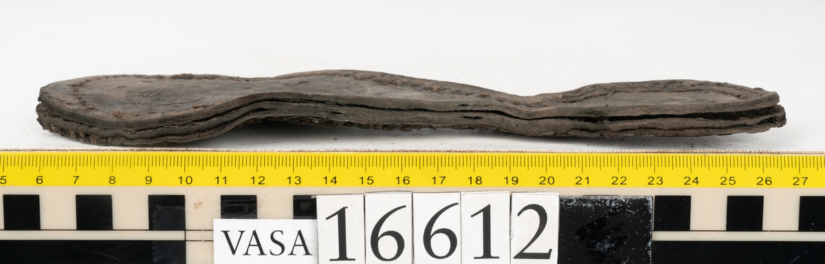 Delar och fragment av två skobottnar till höger- och vänstersko. Totalt 18 delar och fragment.
Sju sulor med kvarsittande tråd. Sulornas längd varierar mellan 220-230 mm, största bredden varierar mellan 65-75 mm, minsta bredden mellan 25-35 mm och hälbredden mellan 45-50 mm. Lädret till sulorna är kraftigt.
Klackar 16612 samt 16612:1 består av vardera fem klacklappar med kvarsittandskopligg. Klacklapparna är spaltade. I materialet finns en löst liggande klacklapp som tillhör klack 16621:1.
Tre delar holtrand med kvarsittande tråd.
Tre fragment från skobotten.