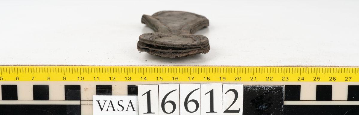 Delar och fragment av två skobottnar till höger- och vänstersko. Totalt 18 delar och fragment.
Sju sulor med kvarsittande tråd. Sulornas längd varierar mellan 220-230 mm, största bredden varierar mellan 65-75 mm, minsta bredden mellan 25-35 mm och hälbredden mellan 45-50 mm. Lädret till sulorna är kraftigt.
Klackar 16612 samt 16612:1 består av vardera fem klacklappar med kvarsittandskopligg. Klacklapparna är spaltade. I materialet finns en löst liggande klacklapp som tillhör klack 16621:1.
Tre delar holtrand med kvarsittande tråd.
Tre fragment från skobotten.