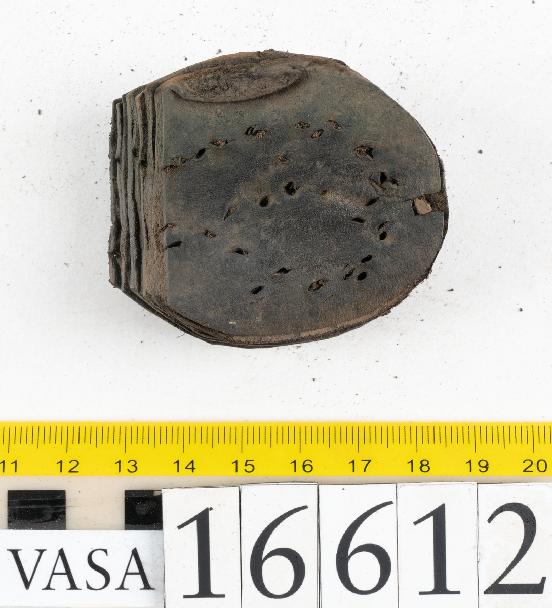 Delar och fragment av två skobottnar till höger- och vänstersko. Totalt 18 delar och fragment.
Sju sulor med kvarsittande tråd. Sulornas längd varierar mellan 220-230 mm, största bredden varierar mellan 65-75 mm, minsta bredden mellan 25-35 mm och hälbredden mellan 45-50 mm. Lädret till sulorna är kraftigt.
Klackar 16612 samt 16612:1 består av vardera fem klacklappar med kvarsittandskopligg. Klacklapparna är spaltade. I materialet finns en löst liggande klacklapp som tillhör klack 16621:1.
Tre delar holtrand med kvarsittande tråd.
Tre fragment från skobotten.