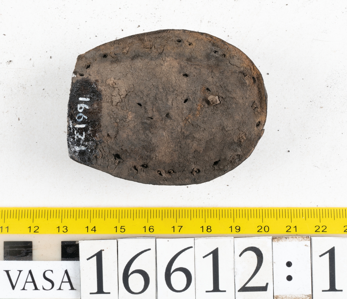 Delar och fragment av två skobottnar till höger- och vänstersko. Totalt 18 delar och fragment.
Sju sulor med kvarsittande tråd. Sulornas längd varierar mellan 220-230 mm, största bredden varierar mellan 65-75 mm, minsta bredden mellan 25-35 mm och hälbredden mellan 45-50 mm. Lädret till sulorna är kraftigt.
Klackar 16612 samt 16612:1 består av vardera fem klacklappar med kvarsittandskopligg. Klacklapparna är spaltade. I materialet finns en löst liggande klacklapp som tillhör klack 16621:1.
Tre delar holtrand med kvarsittande tråd.
Tre fragment från skobotten.