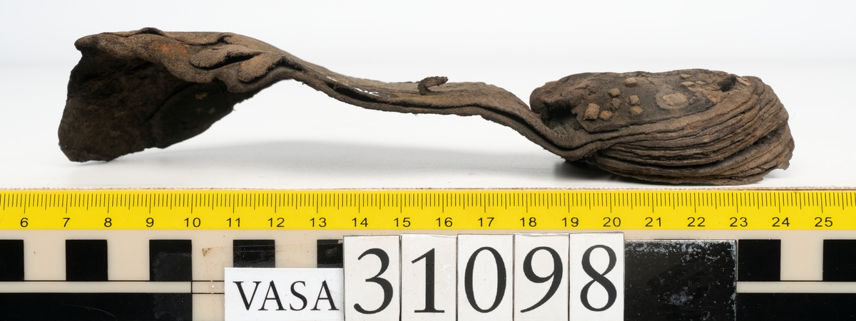 Dokumentation 1997:
Tre delar av sko: en del av en skobotten, en klacklapp och ett ovanläder samt två fragment som lossnat från dessa.
Del av skobotten i form av en yttersula med kvarsittande klack. Klacken är uppbyggd av 5-6 klacklappar. Sulans undersida är ritsad. Sulan är spaltad och tåpartiet är fragmentarisk. Sulan och klacken har kvarsittande träpligg.
En klacklapp med kvarsittande träpligg. Runt ytterkanterna och i klacklappens mitt finns hål efter träpligg.
Ett ovanläder samt en lös bit av plösen. På den lösa biten finns två snörhål. Längs med ovanlädrets ytterkanter löper stygnshål. Köttsidan har börjat att släppa från narvsidan.

Dokumentation 2022:
Del av ovanläder. Framstycke till en öppen svensksko som består av fragment. Tillverkad i läder. Inga dekorationer. Tillhörde en sko som bars på vänster fot. Ovanligt spetsig tå-del. Plösen är skadad och saknas. Det finns delaminering och veckning och inga tecken på lagningar. Det finns en tillhörande klack.
För mer information, se Länkade filer: Uppritning

Text in english:
This is the vamp of an open latchet shoe, made of leather, of stitch-down construction, worn on the left foot, with no decorative features, and an unusually pointed toe. The vamp consists of fragments, with the tongue broken off, and has suffered delamination and creasing. There are no signs of repairs. There is a heel associated with the vamp.
For more information, go to Länkade filer: Uppritning