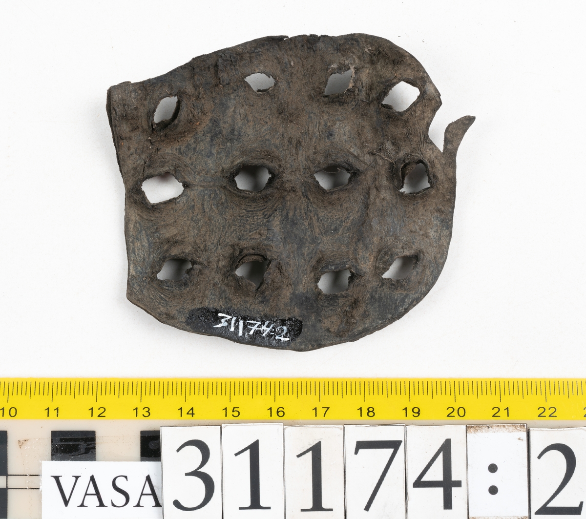 Delar av skobotten.
En sula med kvarsittande del av klacken. Sulan ligger vikt samt är delvis fragmentarisk. Längs med ytterkanterna löper hål efter stygn. Klacken består av fyra klacklappar. Två klacklappar är mycket fragmentariska. Klacken har kvarsittande tråd och träpligg.
En sula. Längs med ytterkanterna löper hål efter träpligg och stygn. Tåpartiet är något fragmentariskt. Lädret är mycket kraftigt.
En klacklapp. Klacklappen är något hästskoformad. På klacklappen syns stora hål efter träpligg.