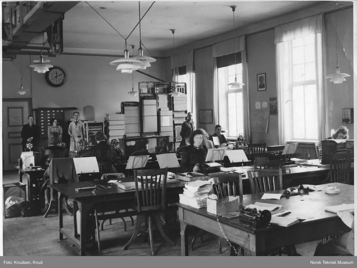 Telegraf- og transmisjonssalen, Bergen telegraf- og rikstelefonstasjon, januar 1945 med to tyske soldater i tjeneste og bilde av Quisling på veggen. 