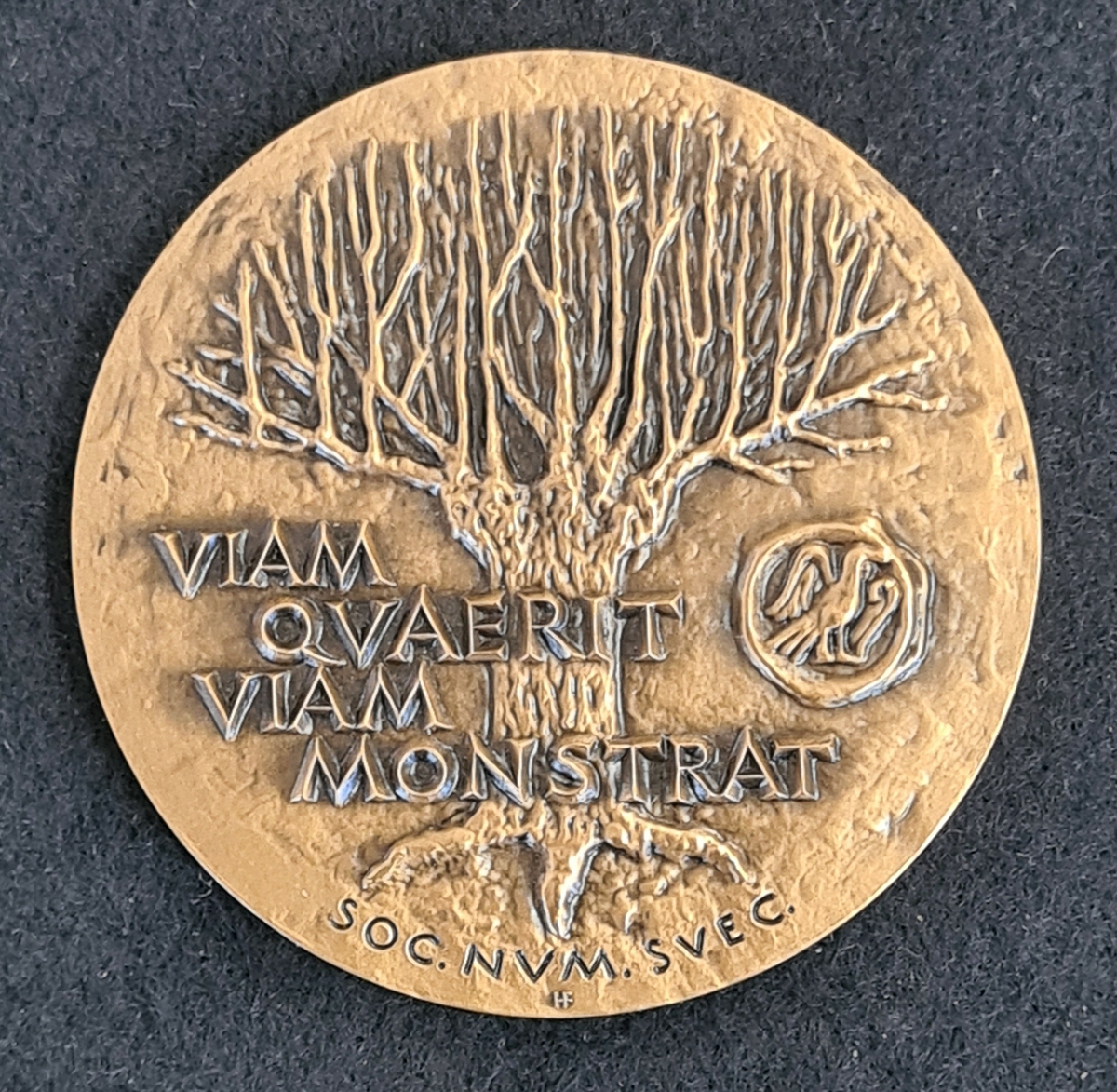 Minnesmedalj i brons. Sid 1: Porträtt i relief och texten: Nils Ludvig Rassmusson 1904-1973.
Sid 2: En pil och texten ''Viam quaerit, viam monstrat = Han utforskar vägen, han visar den''
