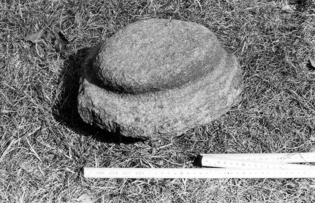 Harplinge sn, Harplinge. Valkesten på hembygdsgården i Harplinge. Enl. äldre muntlig uppgift använd som form vid valkning av filthattar. Naturligt vittrad gråsten. Diameter 28 cm, höjd 14 cm.