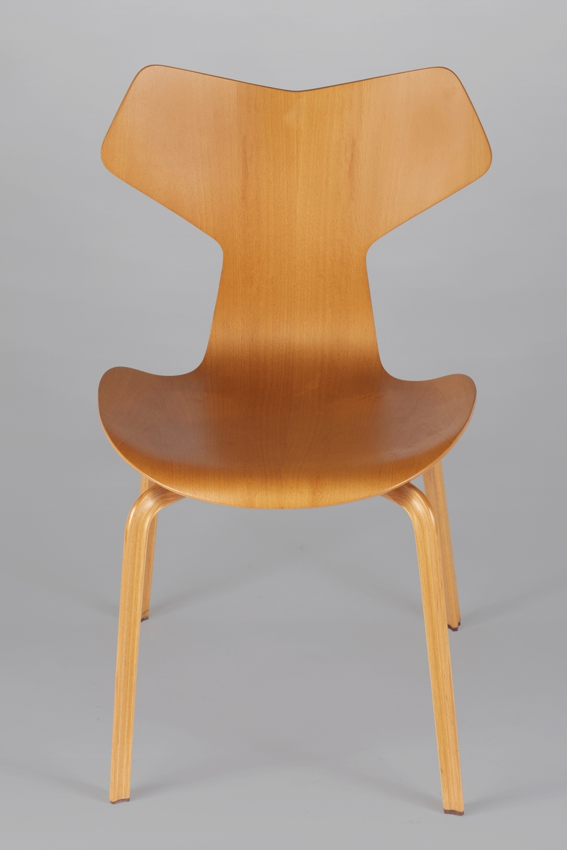 Stol i bøk. Sete og rygg er av finer, som er presset i et stykke. Bena er laget av sammenlimte plater (hver plate er ca. 1 mm tykk), med nesten usynlige fuger imellom. Benets snitt er trekantet med innsvugne sider og en liten påspikret gumminkott nederst.