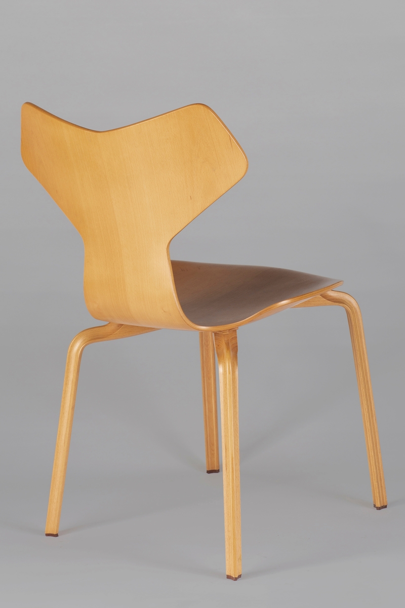 Stol i bøk. Sete og rygg er av finer, som er presset i et stykke. Bena er laget av sammenlimte plater (hver plate er ca. 1 mm tykk), med nesten usynlige fuger imellom. Benets snitt er trekantet med innsvugne sider og en liten påspikret gumminkott nederst.
