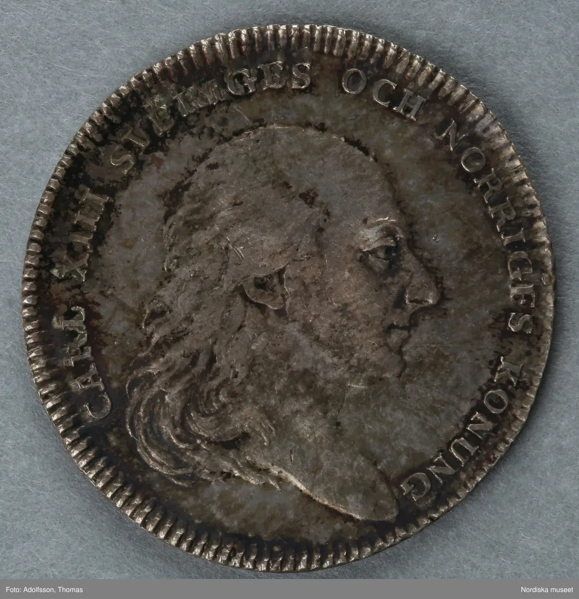 Huvudliggaren:
"2 minnespenningar. Öfver Karl XIII.
a) I koppar. Jfr Hildebrand, del II, sid 278, nr 5
b) I silfver. Jfr Hildebrand del II, sid 290, nr 23."