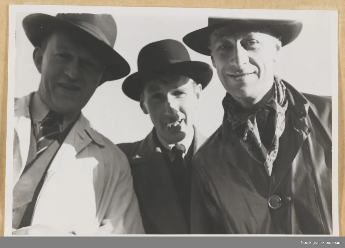 Gruppebilde av tre menn med hatt og frakk, halvnært portrettformat. Fotografert i forbindelse med Vestlandsk Trykkerstevne i Stavanger, 1948.
