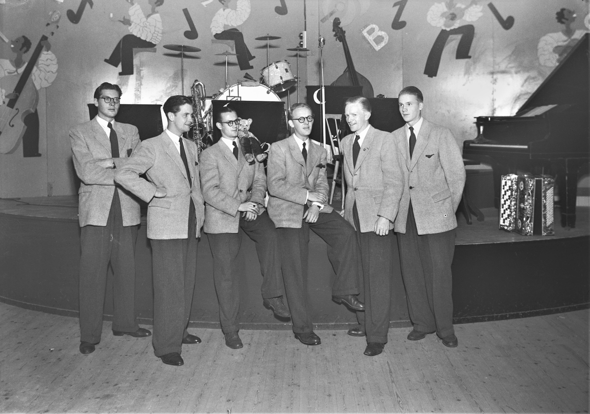 Orkestern Moon band spelar i Nöjesparken i september 1943. Första bilden visar sexmannabandet på scen och på bild 2 står de samlade nedanför scenen. De har med en nalle som mascot. På väggen en målad dekor med noter och musiker. (Se även bild GB2_4017)

Moon band bildades 1932-33 av bröderna Janne och Olle Olausson, men ombildades omkring 1940 med följande sättning: Sten-Gunnar Svensson, trummor; Rune Svensson, dragspel (senare även piano, som på bilden); Sigge Börjesson, trumpet; Yngve Persson, saxofon; Bertil "Lången" Olsson, gitarr; Eric Nyholm, piano (ersattes av Rune). Gunnar Karlsson tillkom på kontrabas.