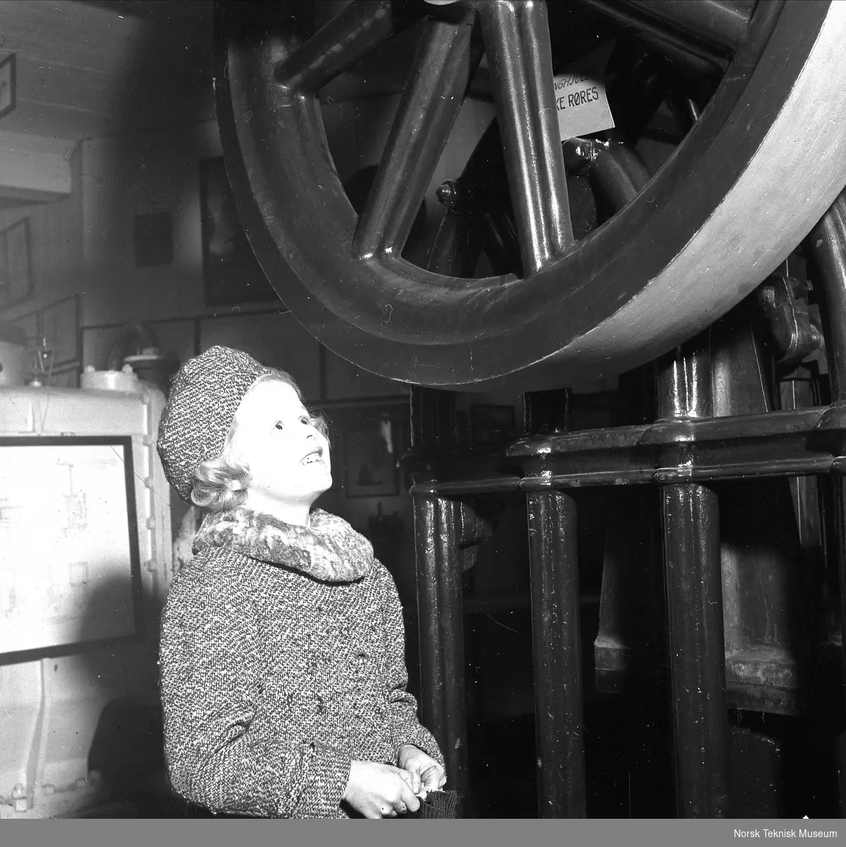 En søndag i museet, liten pike studerer gotisk dampmaskin, 9. november 1941 (Vibeke Lind)