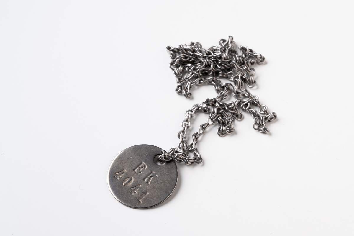 Id-brickor, 10 st, i originalförpackning, utrustning inom civilförsvar. Runda brickor av metall präglade: E K 4041; E K 4042; E K 4043; E K 4044; E K 4045; E K 4046; E K 4047; E K 4048; E K 4049; respektive E K 4050. Brickorna är försedda med metallkedja. Varje bricka förvaras i en liten papperspåse försluten med mässingsklämma. Påsarna är stämplade med respektive nummer:  4041,  4042,  4043,  4044,  4045,  4046,  4047,  4048,  4049 och  4050. Oanvända. JM.568115:9:1-10.

Vid förvärvstillfället var påsarna inlindade i tidningspapper ur Göteborgs Handels- och Sjöfarts-tidning, daterad 1 mars 1957. Paketet var placerat i ett brunt kuvert, stämplat: "TJÄNSTE. KUNGL VATTENFALLSSTYERELSEN". På kuvertet finns handsrkriven text: "Södra Vätterns Kraftaktiebolag 4041-4050 = 10 st identitetsbrickor Jönköping".

Oanvända.

Se Historik.