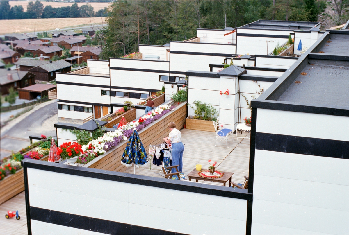 En kvinne står på en terrasseleilighet.