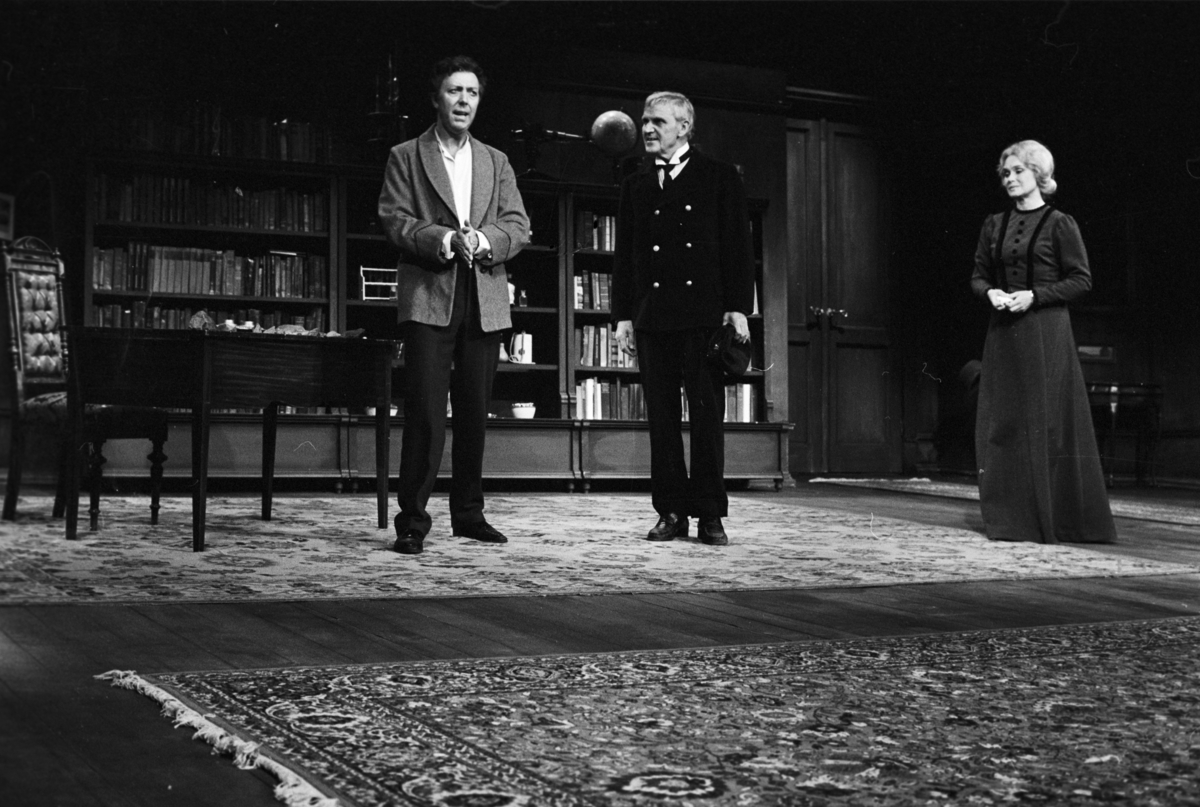 Scene fra Nationaltheaterets oppsetning av Henrik Ibsens "En folkefiende". Forestillingen hadde premiere 27. september 1979. Charles Marowitz hadde regi, og medvirkende var blant annet Per Theodor Haugen som Dr. Thomas Stockmann, Ingerid Vardund som Fru Stockmann og Tor Stokke som Peter Stockmann. 