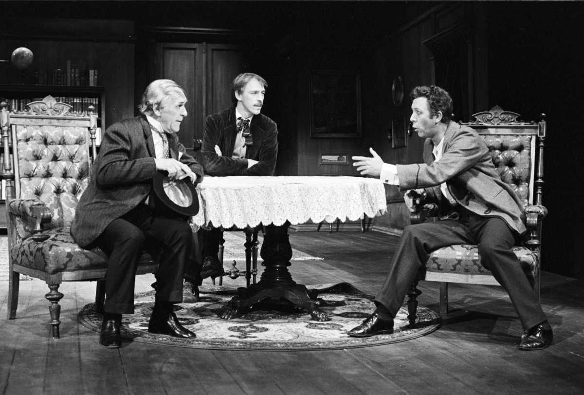 Scene fra Nationaltheaterets oppsetning av Henrik Ibsens "En folkefiende". Forestillingen hadde premiere 27. september 1979. Charles Marowitz hadde regi, og medvirkende var blant annet Per Theodor Haugen som Dr. Thomas Stockmann, Ingerid Vardund som Fru Stockmann og Tor Stokke som Peter Stockmann. 