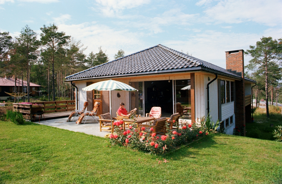 Mann leser avisa på terrassen til et Bloch Watne hus