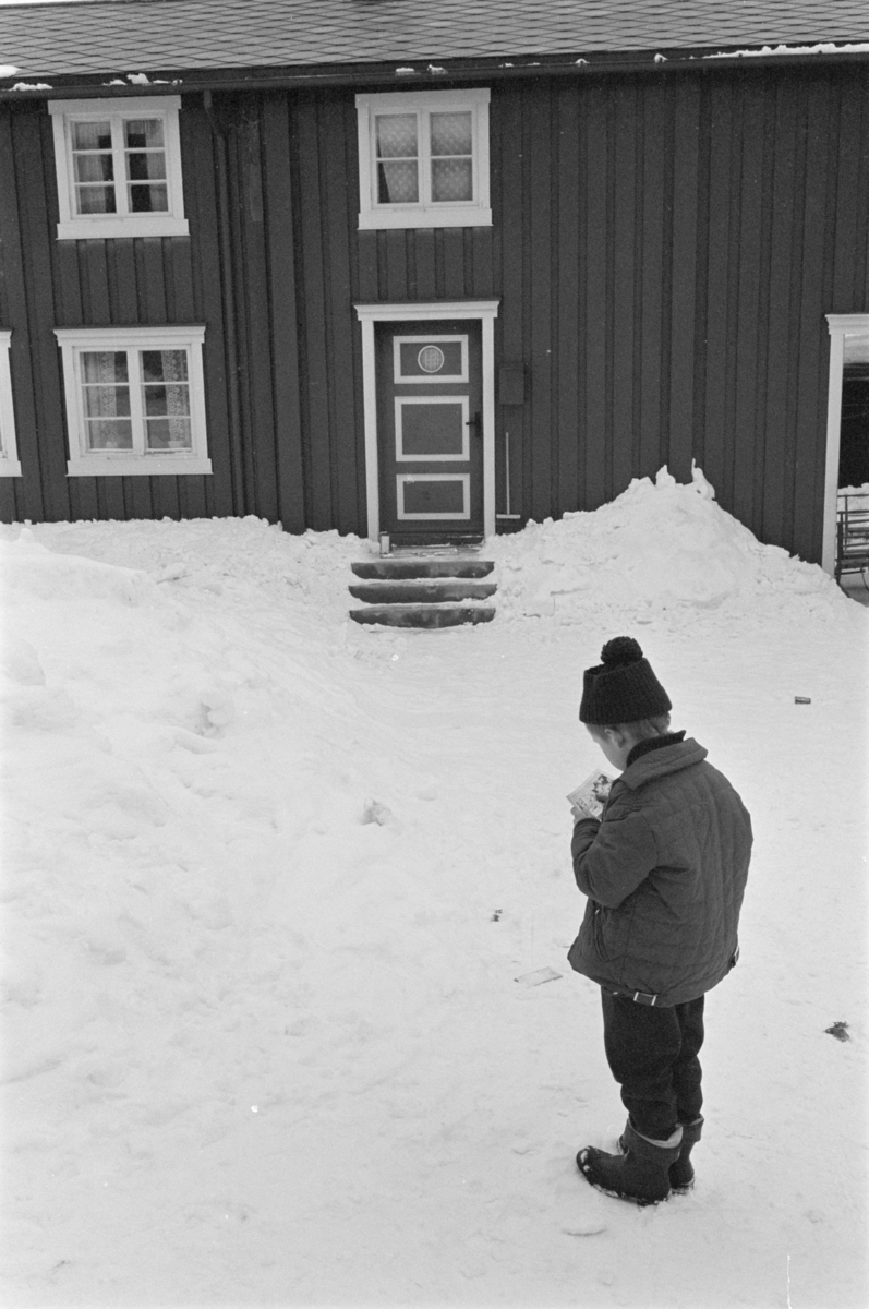 Et barn i snøen foran et bolighus på Røros.