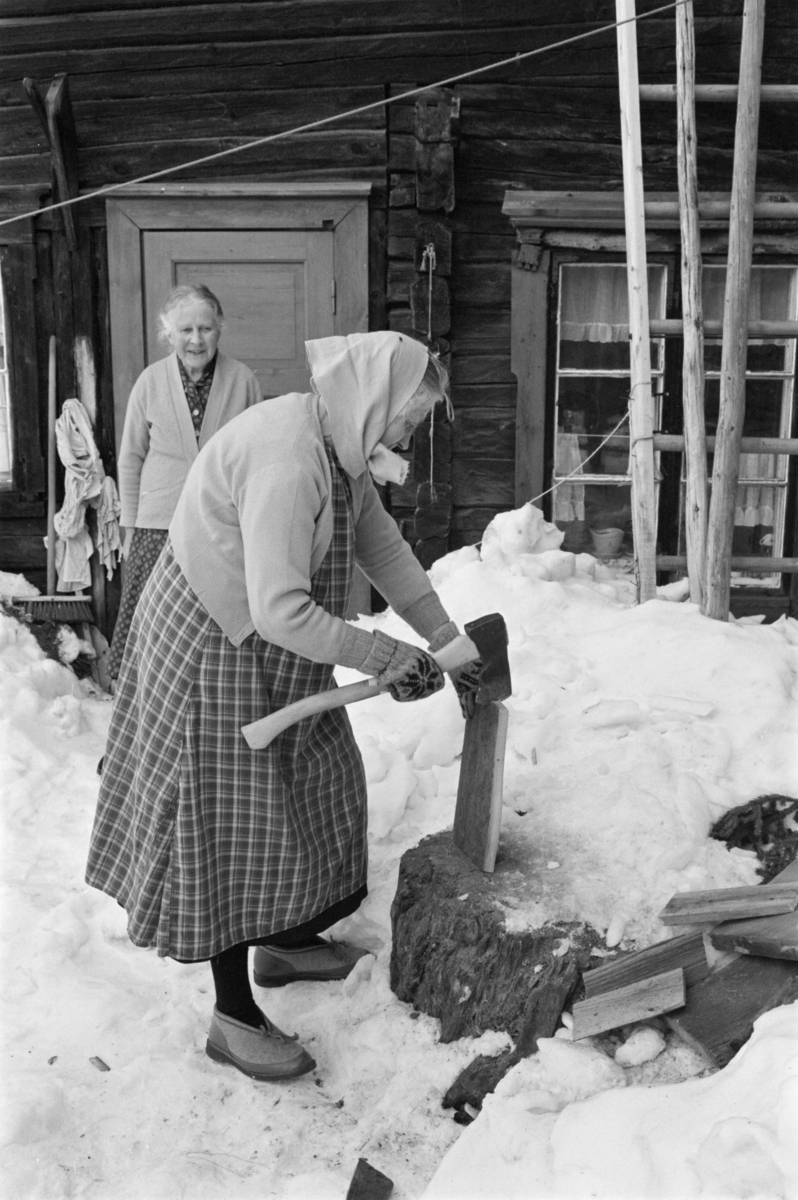 En eldre kvinne hogger ved.