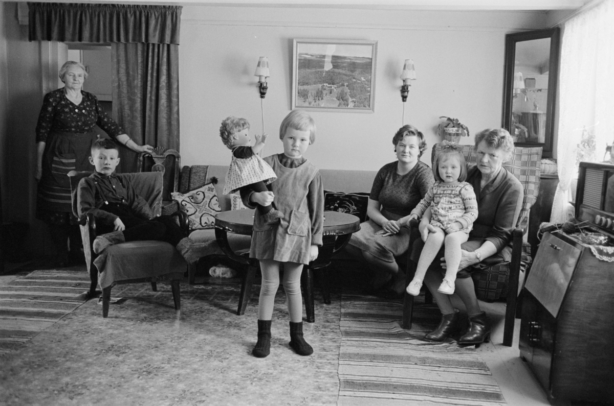 Barn og voksne sitter i en sofagruppe.