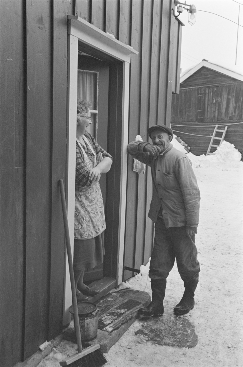 En kvinne og en mann står i en døråpning på Røros.