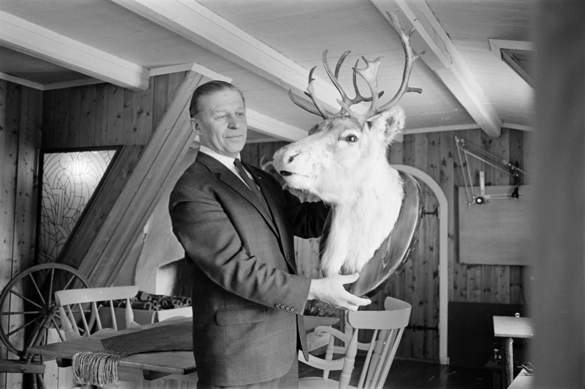 Portrett av en mann med et utstoppet reinsdyrhode.