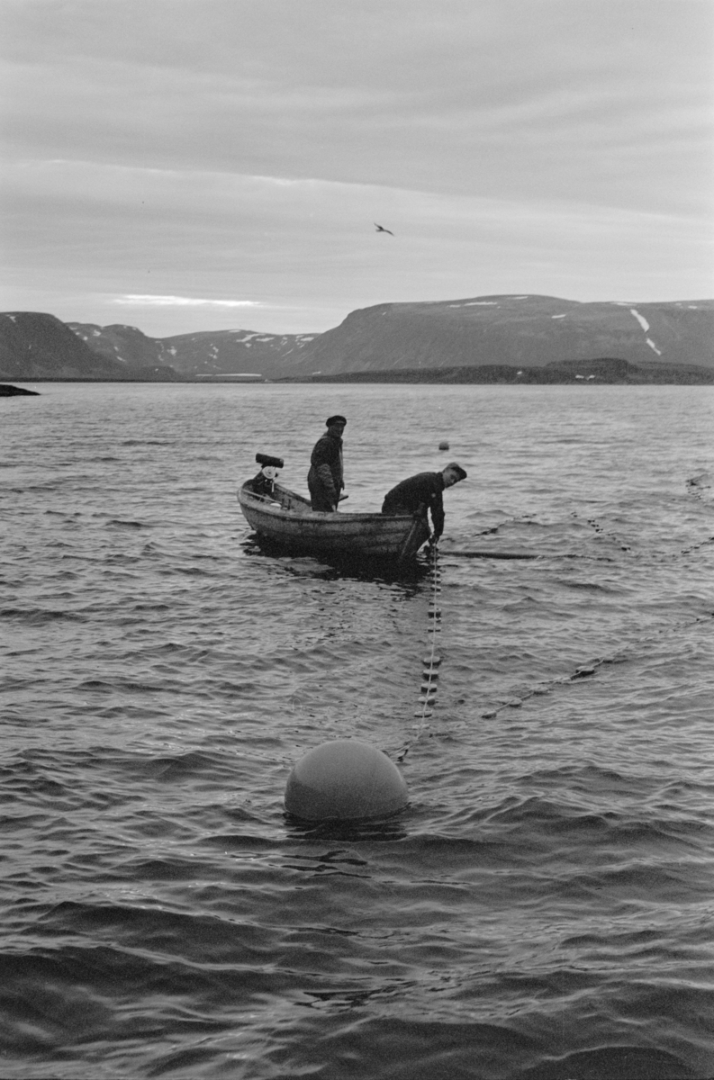 Folk i båt på garnfiske.