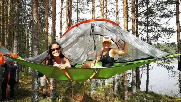 To jenter sitter i et tretopptelt på Finnskogen.